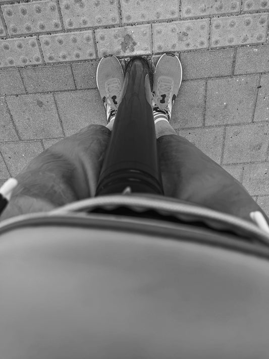 A person standing in front of a brick wall