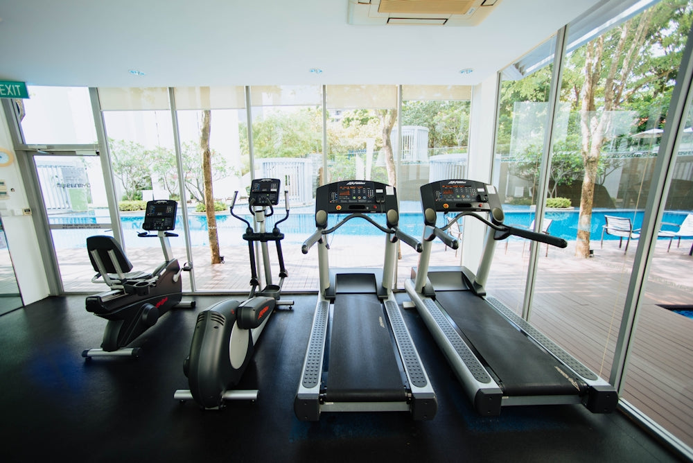 black treadmills and elliptical trainers in glass room