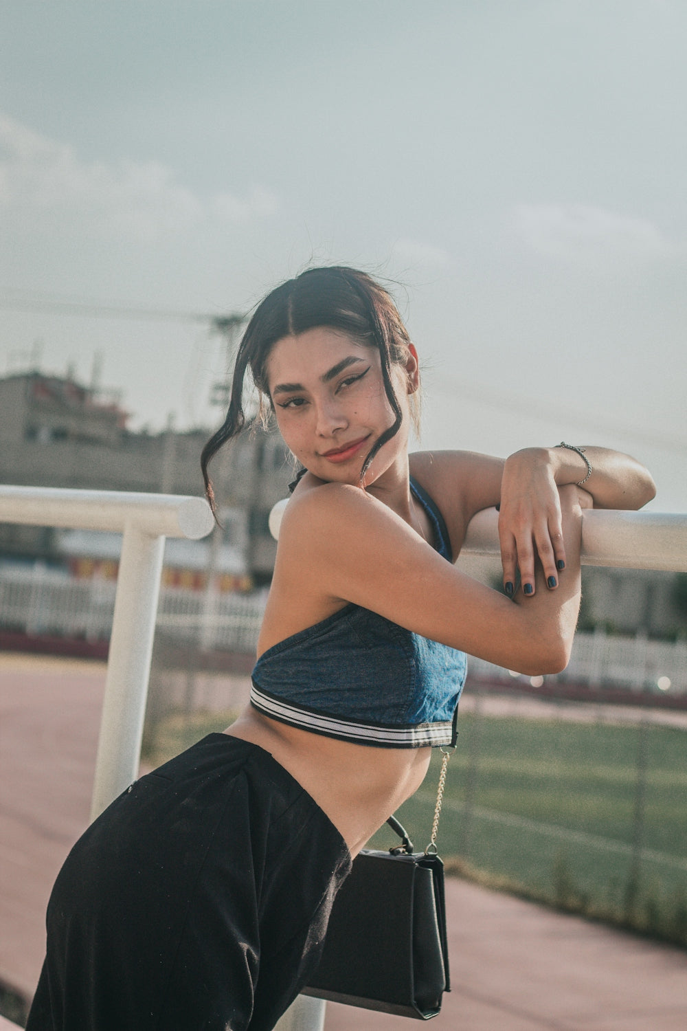a woman in a sports bra top leaning on a rail